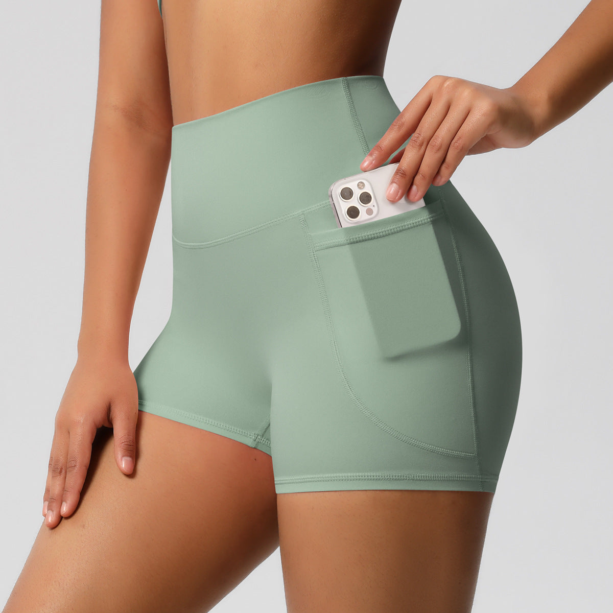 Shorts de ioga femininos com bolsos, modelo três-quartos, cor pêssego.